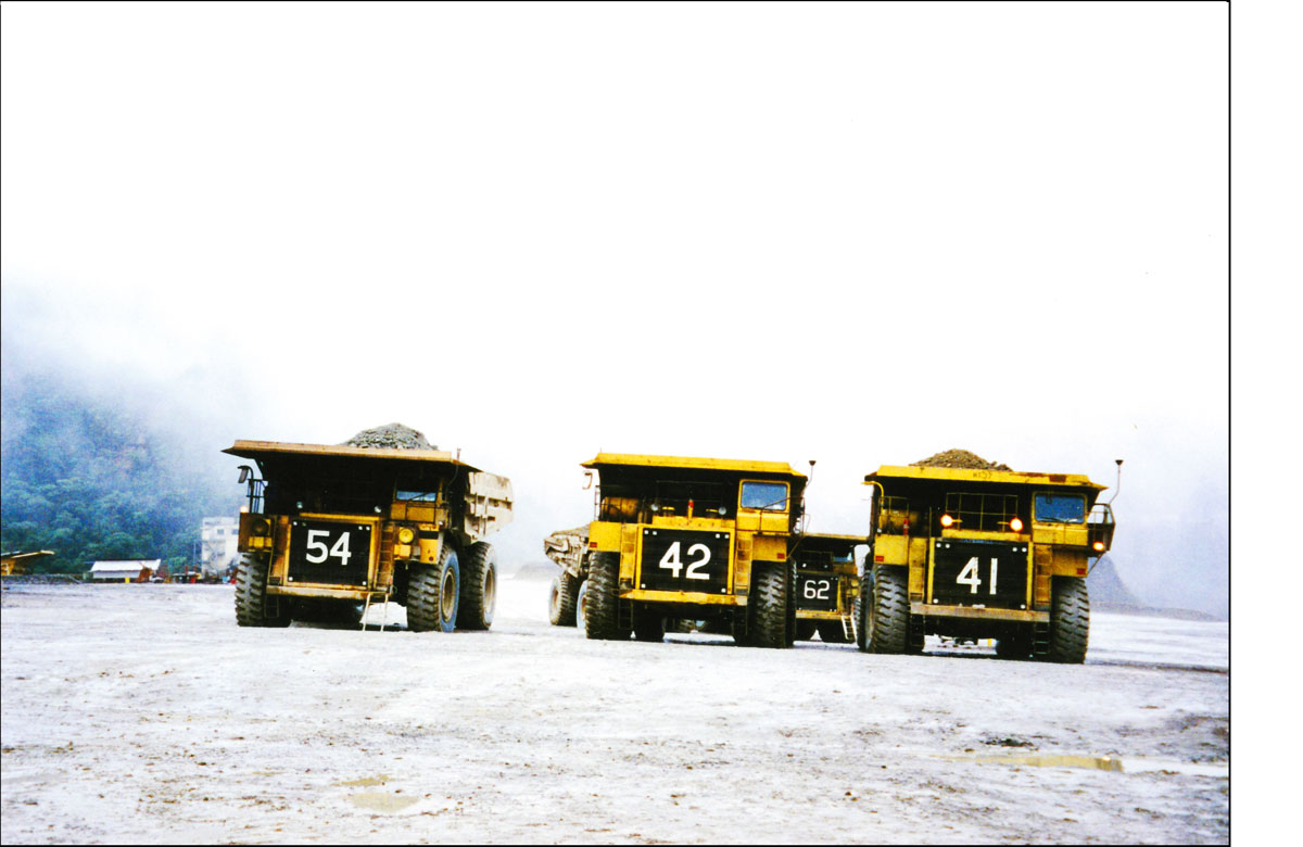 Dump trucks in the mist - Ok Tedi.
